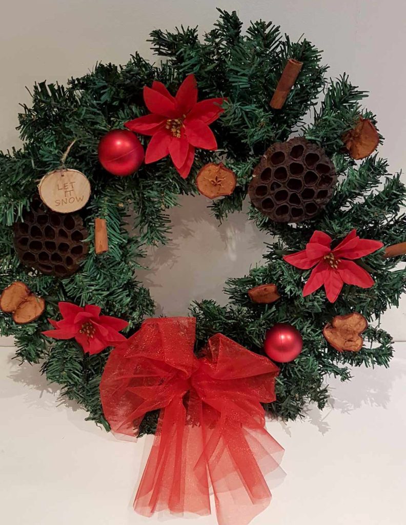 Image: Christmas wreath with a red bow and decorations.